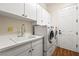 Laundry room equipped with washer, dryer, sink and white cabinets at 6907 May Basket Ave, Las Vegas, NV 89131
