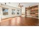 Spacious living room with a fireplace, wood paneling, large windows, and wood laminate flooring at 6907 May Basket Ave, Las Vegas, NV 89131