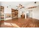 Bright living room with a fireplace, wood paneling, laminate wood flooring, ceiling fan and kitchen views at 6907 May Basket Ave, Las Vegas, NV 89131