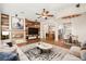 Inviting living room with a fireplace, wood accent wall, ceiling fan, and views into the kitchen and dining area at 6907 May Basket Ave, Las Vegas, NV 89131