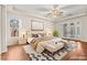 Serene main bedroom with a tray ceiling, ceiling fan, hardwood floors, a sitting area, and access to the backyard at 6907 May Basket Ave, Las Vegas, NV 89131