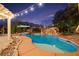 Inviting backyard pool and spa with rock features, lush landscaping, and a covered pergola at 6907 May Basket Ave, Las Vegas, NV 89131