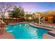 Backyard in-ground pool with rock waterfall, fountain, and desert landscaping at 6907 May Basket Ave, Las Vegas, NV 89131