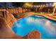 Backyard pool with a rock waterfall feature and lush landscaping creates a tranquil retreat at 6907 May Basket Ave, Las Vegas, NV 89131