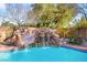 Backyard pool featuring a rock waterfall and mature landscaping at 6907 May Basket Ave, Las Vegas, NV 89131