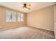 Neutral bedroom with a ceiling fan, light neutral walls and carpet, and bright windows at 8065 Starling View Ct, Las Vegas, NV 89166