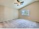 Large bedroom with neutral walls and carpet, bright windows, and a ceiling fan at 8065 Starling View Ct, Las Vegas, NV 89166