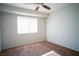 A well-lit bedroom with plush carpeting, a ceiling fan, and natural light from a window at 8160 Autumn Star Ave, Las Vegas, NV 89145