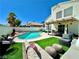 Inviting backyard featuring a pristine pool, lush artificial turf, and an outdoor seating area, perfect for relaxing at 8233 Hydra Ln, Las Vegas, NV 89128