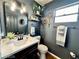 Contemporary bathroom with dark walls, modern fixtures, and a decorative mirror at 8233 Hydra Ln, Las Vegas, NV 89128