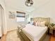 Bright bedroom featuring a bed with a cream colored cover and a modern light fixture at 8233 Hydra Ln, Las Vegas, NV 89128