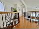 Upstairs hallway with wood floors, ornate iron railing, and views into other rooms at 8233 Hydra Ln, Las Vegas, NV 89128