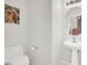 Powder room features a pedestal sink, toilet, and decorative wall art in a neutral color scheme at 8426 Sluman Ct, Las Vegas, NV 89128