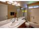 Well-lit bathroom features a large mirror, vanity with oak cabinets, and a shower/tub combination with a patterned curtain at 8582 Manalang Rd, Las Vegas, NV 89123