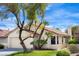 Charming one-story home featuring a two-car garage, lush landscaping, and a beautiful terracotta tile roof at 8582 Manalang Rd, Las Vegas, NV 89123