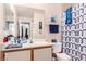 Neutral bathroom featuring a single sink vanity, toilet, and shower with blue decorative accents at 8600 W Charleston Blvd # 2190, Las Vegas, NV 89117