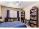 Well-organized bedroom with bookshelves, record player and dark furniture, bathed in natural light at 8600 W Charleston Blvd # 2190, Las Vegas, NV 89117