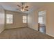 Carpeted bedroom with ceiling fan, two windows, and ensuite bathroom at 8980 High Horizon Ave, Las Vegas, NV 89149