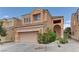 Two-story home with a tan stucco exterior, tile roof, and two-car garage at 8980 High Horizon Ave, Las Vegas, NV 89149