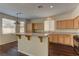 Well-lit kitchen with dark floors, breakfast bar, and lots of wood cabinets at 8980 High Horizon Ave, Las Vegas, NV 89149