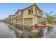 Attractive two-story townhomes with attached garages line a street on a wet day at 965 Nevada State Dr # 8202, Henderson, NV 89002