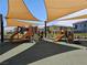 Close up view of playground equipment under shade covers with neighborhood homes in the background at 965 Nevada State Dr # 8202, Henderson, NV 89002