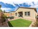 A cozy backyard featuring artificial turf, a patio set, and a covered seating area at 9993 Skye Gazer Ave, Las Vegas, NV 89166
