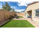 A cozy backyard featuring artificial turf, a patio set, and a covered seating area at 9993 Skye Gazer Ave, Las Vegas, NV 89166