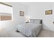 Cozy bedroom with plush gray bedding, accent art, and a bright window view at 9993 Skye Gazer Ave, Las Vegas, NV 89166