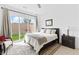 Bright bedroom with sliding door access to the backyard, features plush bedding, and accent seating at 9993 Skye Gazer Ave, Las Vegas, NV 89166