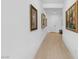 Hallway with white walls, light wood floors, and framed art at 9993 Skye Gazer Ave, Las Vegas, NV 89166
