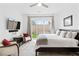 Bright bedroom with backyard access, plush bedding, stylish rug, and comfortable accent chairs at 9993 Skye Gazer Ave, Las Vegas, NV 89166