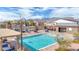 A community pool surrounded by lounge chairs, tables, and well maintained landscaping at 9993 Skye Gazer Ave, Las Vegas, NV 89166