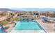 An inviting community pool surrounded by lounge chairs, tables, and well maintained landscaping at 9993 Skye Gazer Ave, Las Vegas, NV 89166