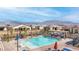 A community pool surrounded by lounge chairs, tables, and well maintained landscaping at 9993 Skye Gazer Ave, Las Vegas, NV 89166