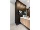Modern bathroom showcasing a wood vanity with a white countertop, decorative art, and tile flooring at 10 Sand Star Ln, Henderson, NV 89011