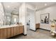 Bright primary bathroom showcasing double sinks, wood cabinets, tile floors, and a walk-in shower at 10 Sand Star Ln, Henderson, NV 89011