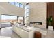 Bright living room featuring a stone fireplace, soaring windows, modern furniture and seamless indoor-outdoor living at 10 Sand Star Ln, Henderson, NV 89011