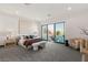 Bright main bedroom with a king bed, sitting area, and large windows overlooking the outdoor patio at 10 Sand Star Ln, Henderson, NV 89011