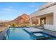 Contemporary backyard features a stunning pool with cascading water, offering a tranquil oasis at 10 Sand Star Ln, Henderson, NV 89011