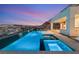 Beautiful pool with a waterfall feature, spa, and breathtaking views at twilight at 10 Sand Star Ln, Henderson, NV 89011
