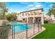 Beautiful backyard with a sparkling pool, lush grass, and a covered patio area at 10412 Mansion Hills Ave, Las Vegas, NV 89144