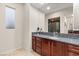 Bathroom featuring vanity with granite countertop, large mirror, and a glimpse into the tiled shower at 10412 Mansion Hills Ave, Las Vegas, NV 89144