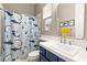 bathroom with shark themed shower curtain, sink, toilet and modern mirror at 10412 Mansion Hills Ave, Las Vegas, NV 89144