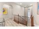 Upstairs hallway with wood-look floors, arches and staircase with dark wood banister at 10412 Mansion Hills Ave, Las Vegas, NV 89144