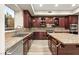 Spacious kitchen with granite countertops, stainless steel appliances, island, and custom wood cabinetry at 10412 Mansion Hills Ave, Las Vegas, NV 89144