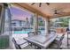Covered patio with dining set overlooking pool area and landscaped backyard at 10412 Mansion Hills Ave, Las Vegas, NV 89144