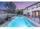 Beautiful backyard with a sparkling pool, waterfall features, and mature trees at 10412 Mansion Hills Ave, Las Vegas, NV 89144