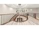 Grand foyer with curved staircase, modern chandelier, and an open view of the lower level at 10412 Mansion Hills Ave, Las Vegas, NV 89144