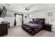 Spacious primary bedroom features plush carpet, a ceiling fan, and large windows at 10604 Sariah Skye Ave, Las Vegas, NV 89166